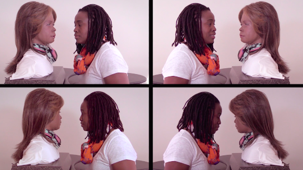 An image of video stills arranged in a grid of two rows and two columns each showing the artist and robot bust facing each other with matching white t-shirts against a white background in a medium close-up.